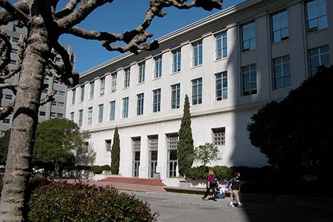 White building with people walking toward steps to entrance